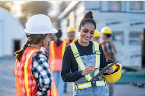 Two female construction workers looking at a document on a job site