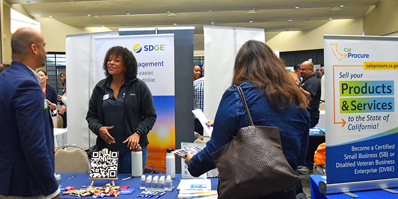 attendees speaking with a vendor at a booth at the Small and Diverse Business Expo.