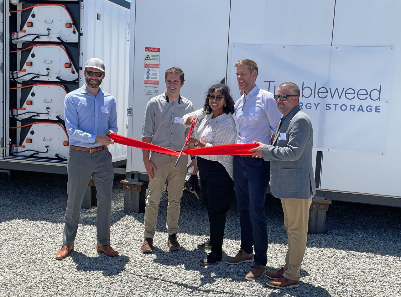 CPUC staff cut a ribbon in front of battery storage units.