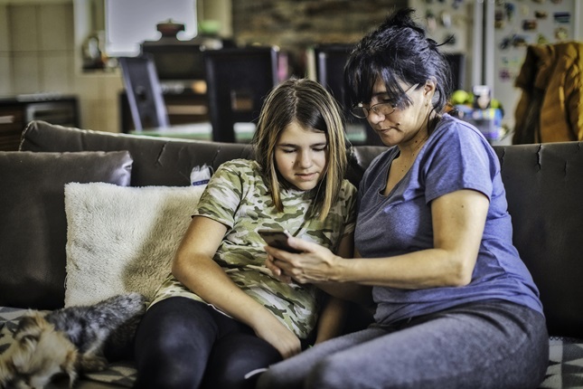 Mother and daughter exploring content on a mobile phone