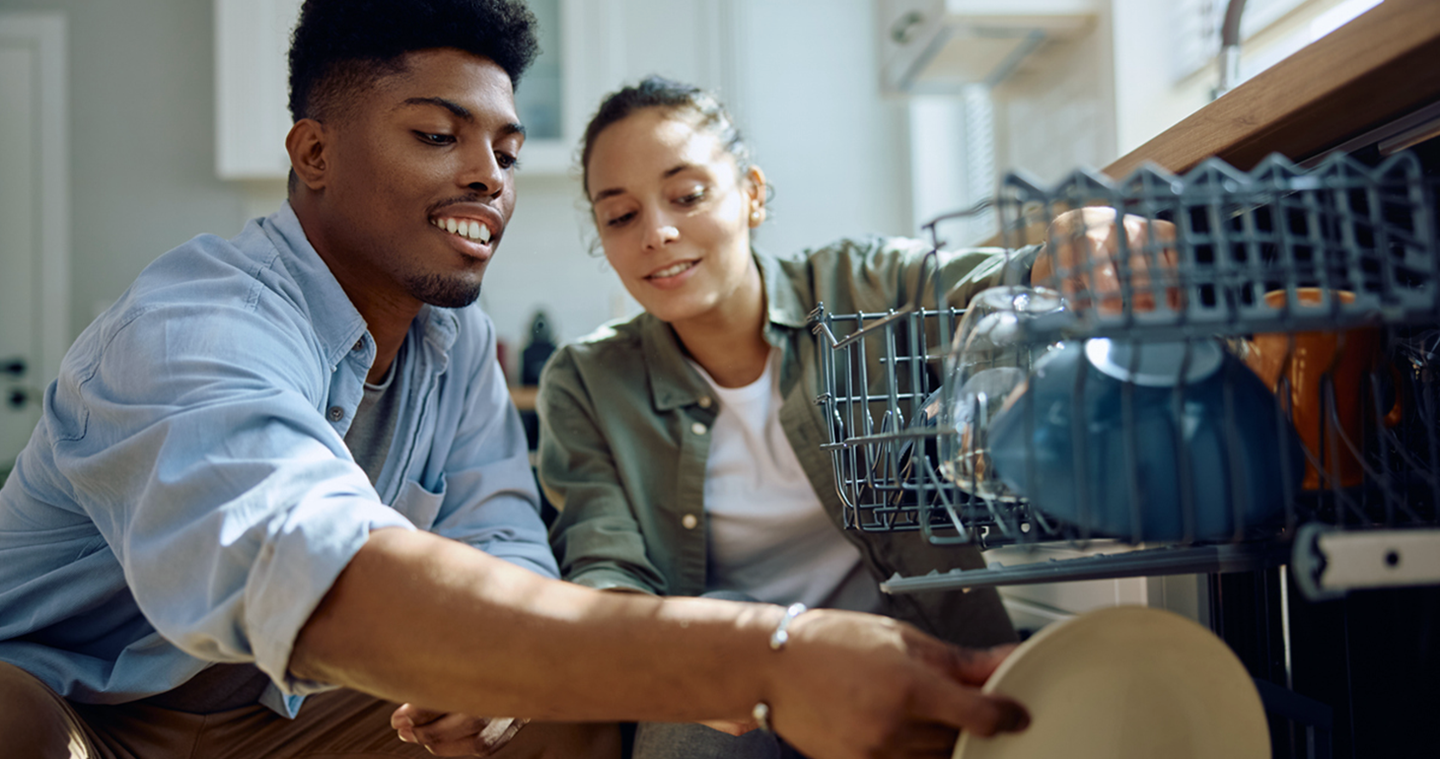 Couple loading dishwasher